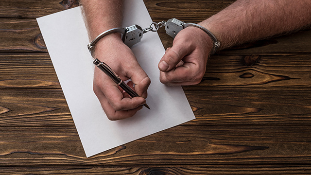 A criminal or prisoner writing down something
