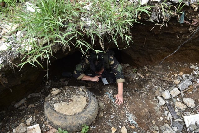 RAT-LIKE. A soldier crawls out of a tunnel connected to the city's underground drainage system, used by militants as cover during the height of the war. Photo by Ted Aljibe/AFP 