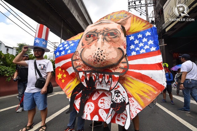 PROTEST. In this file photo during the Labor Day protest on May 1, 2018, protesters carry  an effigy depicting Duterte eating a Filipino. Photo by Alecs Ongcal/Rappler 