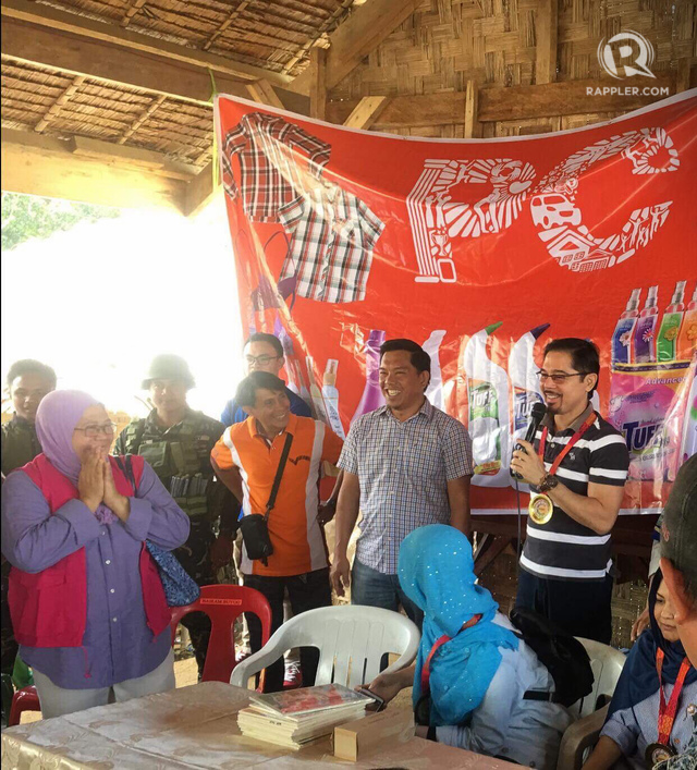 SMILES. Christopher de Leon (right) shares a light moment with Councilor Jun Lacman (second from right), who helped make the outreach possible. 