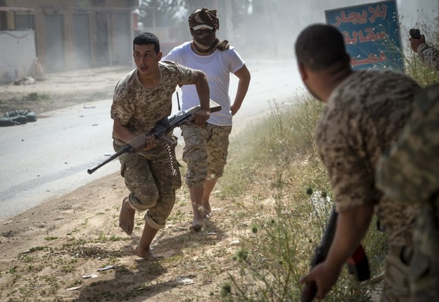 LIBYA CONFLICT. Fighters loyal to the internationally recognized Government of National Accord run for cover during clashes with forces loyal to strongman Khalifa Haftar south of the capital Tripoli's suburb of Ain Zara, on April 25, 2019. Photo by Fadel Senna/AFP 