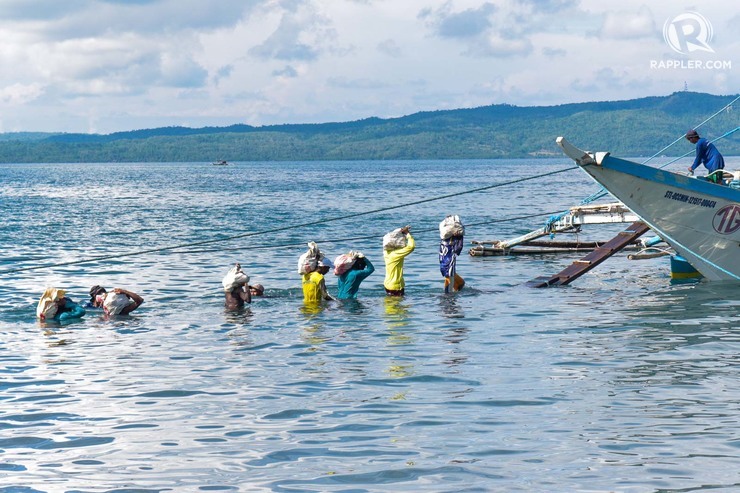 Fishermen line-up to load stone sinkers on a boat headed to Recto Bank on June 21, 2019 at Brgy. San Roque, San Jose Occidental Mindoro. Photo by LeAnne Jazul/Rappler