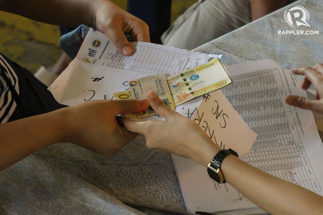 CASH AID. Residents of Barangay Labas in Sta. Rosa, Laguna receive their financial assistance under the government's Emergency Subsidy Program during the last day of payout on May 7, 2020. Photo by Mary Grace dela Cerna / Rappler 