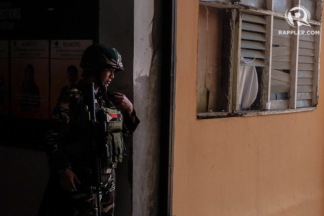 MARAWI CLASHES. A soldier checks on his fellow soldiers over the radio as he holds his post inside Marawi City on June 22, 2017. File photo by Bobby Lagsa/Rappler 