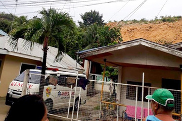 QUICK RESPONSE. Residents look on after a landslide buries homes in Naga City, Cebu. Photo by John Rhay Echavez  