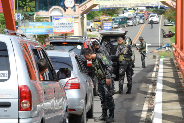 MARTIAL LAW. Police special forces inspect vehicles at a checkpoint near the entrance to Marawi. Photo by Ted Aljibe/AFP 