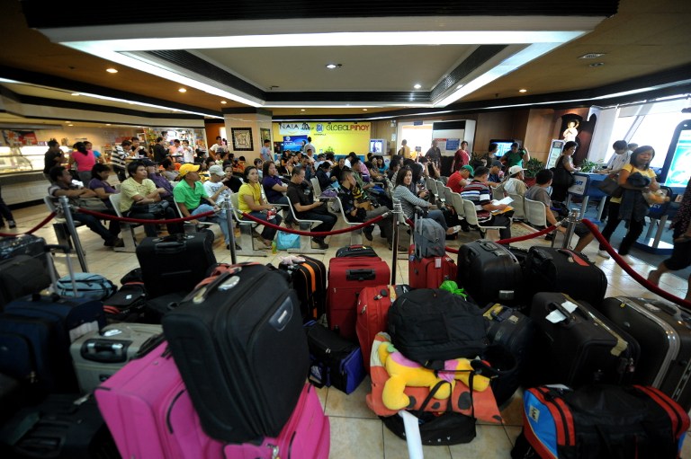 ILLEGAL RECRUITMENT. Some overseas Filipino workers fall into the trap of illegal recruiters due to the government's slow processing of their documents. File photo by Noel Celis/AFP 