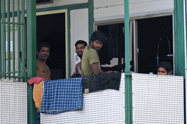 WORKER SLEEVES. Men watch from a dormitory used by foreign workers at Cochrane Lodge 2, which has been converted into an isolation area to prevent the spread of the COVID-19 coronavirus, in Singapore on April 15, 2020. Photo by Roslan Rahman / AFP  