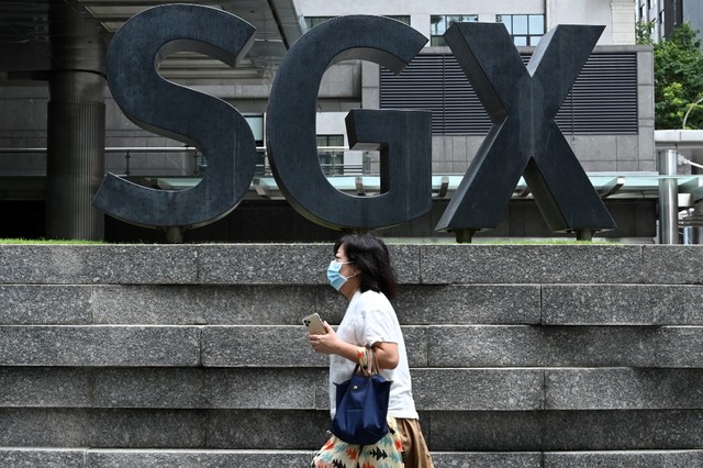 SECURITY MEASURES. A woman, wearing a face mask as a preventative measure against the spread of COVID-19, passes the building of the Singapore Stock Exchange (SGX) on April 7, 2020. Photo by Roslan Rahman / AFP  