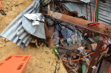 BURIED HOMES. A body is seen among the rubble at the landslide site in Naga City, on the popular tourist island of Cebu on September 20, 2018. Photo by Alan Tangcawan/AFP 