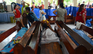 MOURNING. People weep next to the bodies of victims of a landslide in Naga City, on the popular tourist island of Cebu on September 20, 2018. Photo by Alan Tangcawan/AFP 