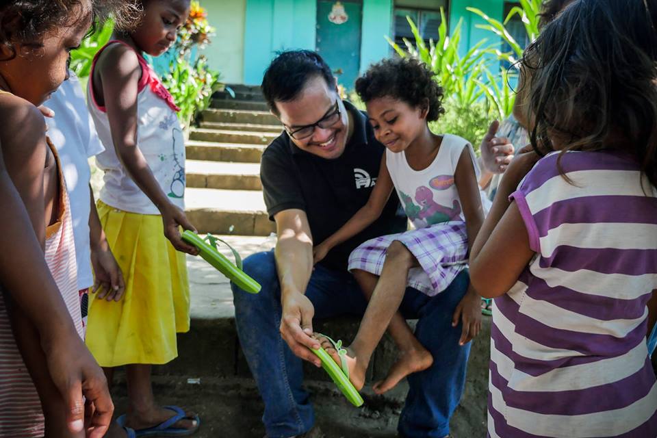 The children are all smiles as they try on their new slippers
 