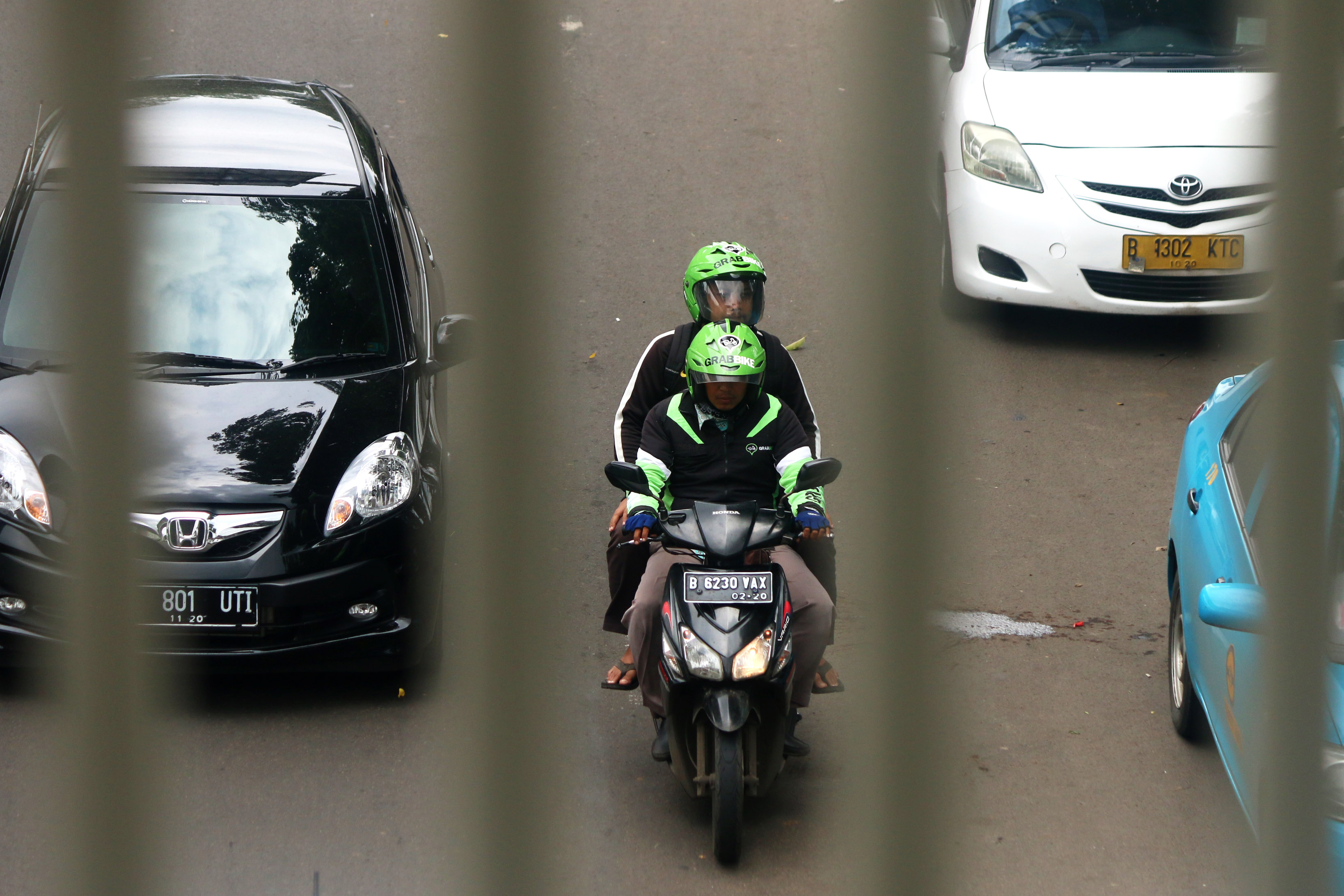 Pengemudi ojek berbasis online mengantar penumpang di kawasan Palmerah Jakarta 18 Desember 2015